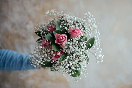 person holding bouquet of pink flowers thumbnail