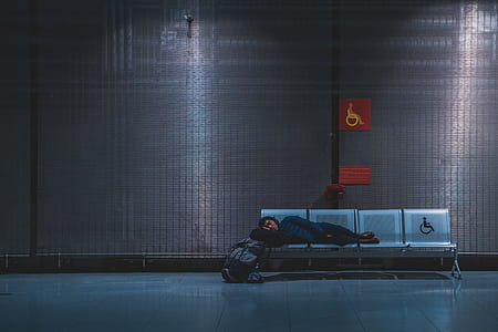 person sleeping on gray steel gang chair thumbnail