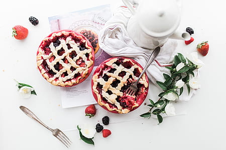 blueberry and raspberry pie on white printer paper near white ceramic teapot thumbnail