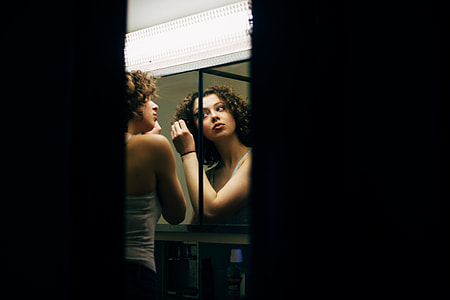 woman fixing her face in front of mirror thumbnail