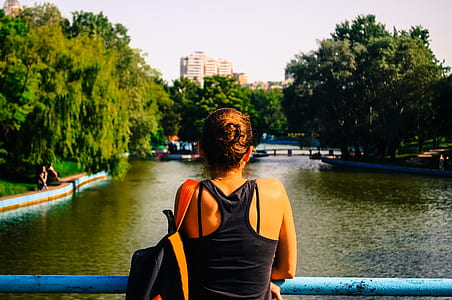 Woman in Black Racerback Top Facing Body of Water and Trees thumbnail