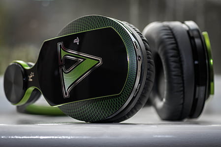 black and green cordless headphones on top of white container thumbnail