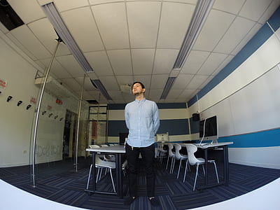 man standing between an alley of tables and chairs thumbnail