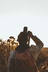man holding DSLR camera taking photo upwards thumbnail