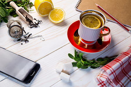 smartphone beside ceramic mug on wooden table thumbnail