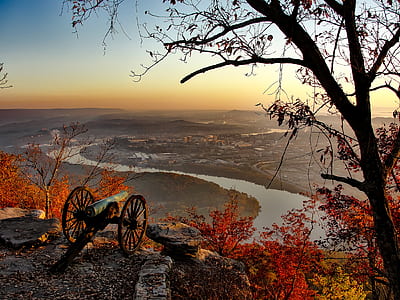photo of black cannon on top of mountain facing city thumbnail
