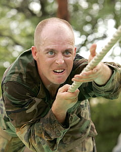man wearing brown and green camouflage army uniform holding white rope at daytime thumbnail
