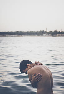 woman hugging his self on body of water thumbnail