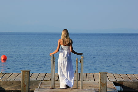 woman wearing white tube dress on brown wooden dock during daytime thumbnail