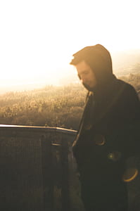man standing beside black metal railings thumbnail