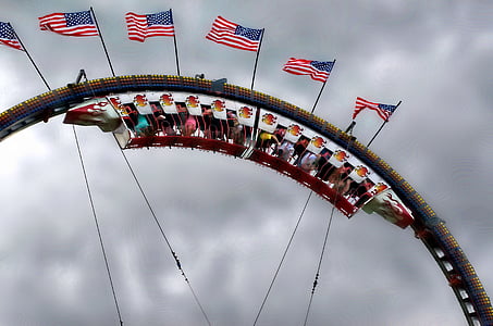 people riding roller coasters under gray sky thumbnail