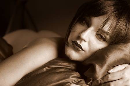 woman lying on bed sepia photo thumbnail