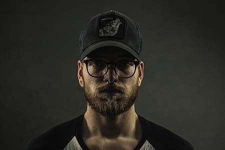 close-up photography of man wearing black fitted cap and black framed clear lens sunglasses thumbnail