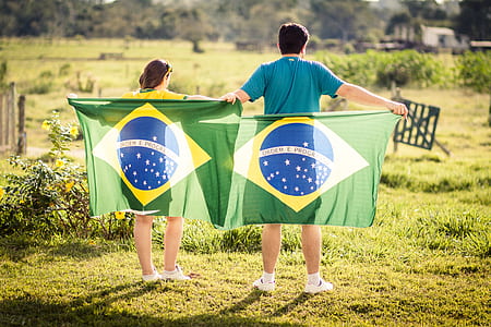 photography of boy and girl holding flag near outdoor during daytime thumbnail