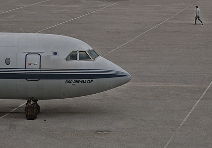 man walks beside white airplane during daytime thumbnail