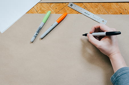 person holding marker on brown paper thumbnail