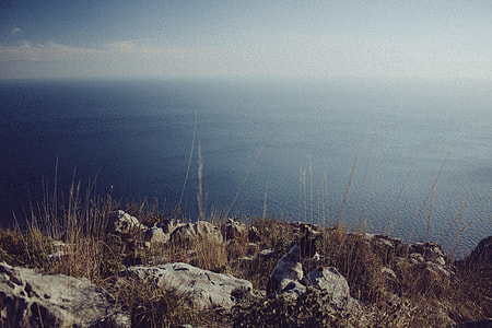 photography of rocky mountain near body of water thumbnail