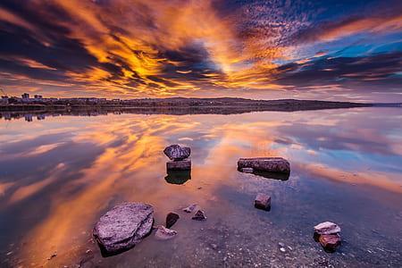 gray rocks covered with body of water during golden hour thumbnail