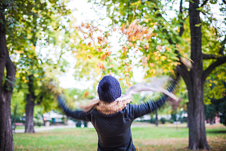 Girl Throwing Autumn Leaves in The Air thumbnail