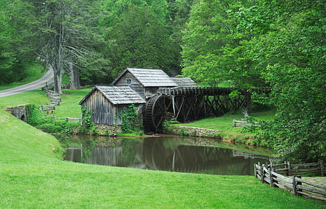 gray house with water mill near body of water thumbnail