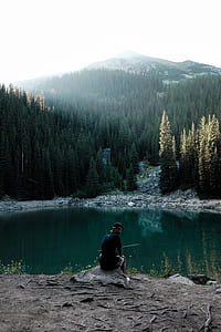 man looking at camera beside body of water thumbnail