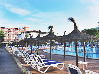 White Plastic Beach Loungers Near Pool at Daytime thumbnail