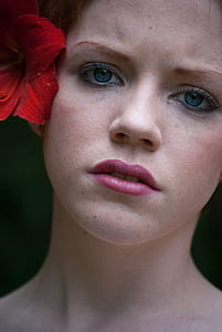 photo of a woman with red lily on ear thumbnail