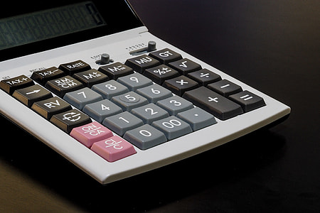 white desk calculator on black surface thumbnail