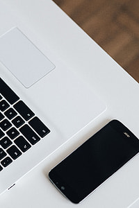 White laptop with smartphone and headphones thumbnail