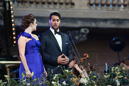 man wearing formal suit talking to woman in blue dress photography during daytime thumbnail