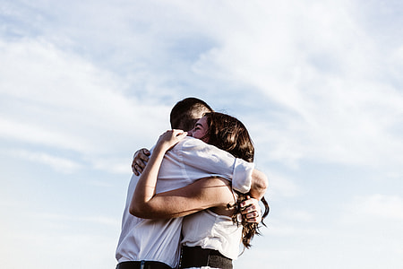 man wearing white dress shirt embracing woman wearing white tank top thumbnail