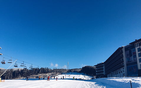 people skiing near gray building thumbnail