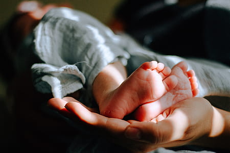 person carrying feet of baby thumbnail