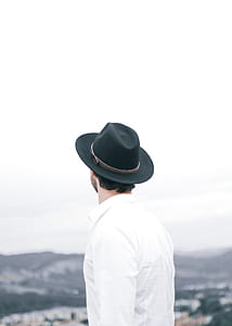 Man In Black Fedora Hat Overlooking Mountain thumbnail