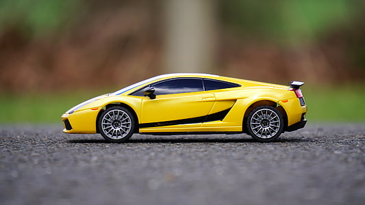 yellow and black Lamborghini Gallardo die-cast metal model on ground during daytime thumbnail