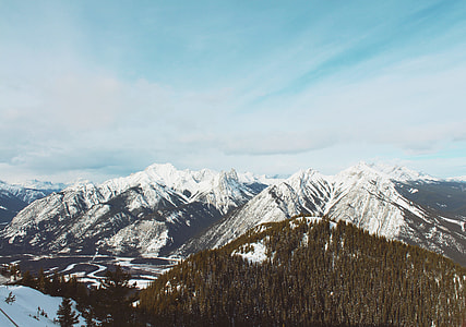 aerial view photography of snowy mountain surrounded of green leafed trees thumbnail