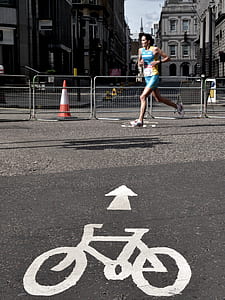 woman in blue sports top running beside fence thumbnail