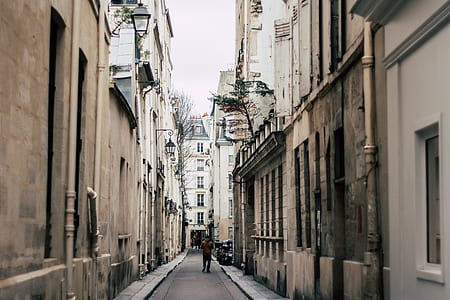 man walking between building thumbnail