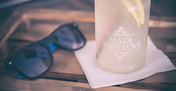 black sunglasses beside Made With Love bottle container thumbnail