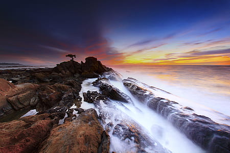 rock formation near seashore during golden hours thumbnail