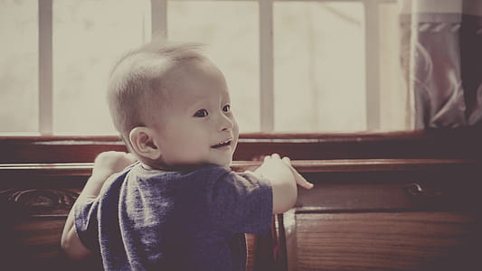 Boy in Blue Crew Neck Shirt Standing in Front of Window thumbnail