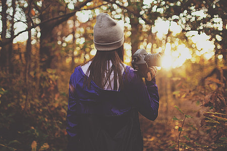 shallow focus photography of woman holding DSLR thumbnail