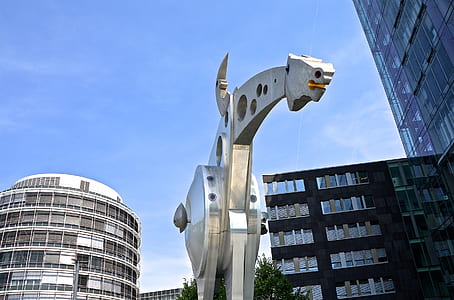 gray steel animal statue under cloudy blue sky thumbnail