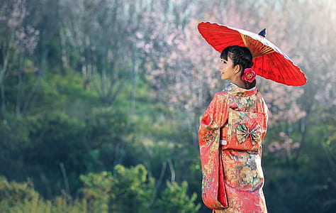 woman holding umbrella during daytime thumbnail