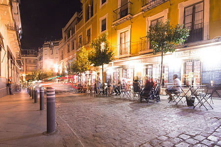 photography of man sitting on outside restaurant at night time thumbnail