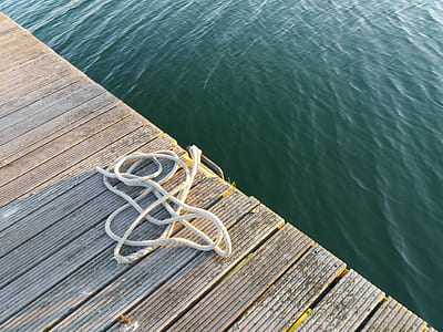 white rope on top of brown wooden boat dock thumbnail