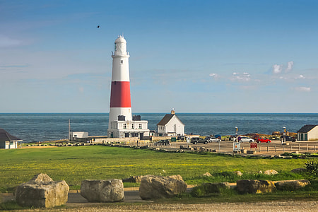 white and red lighthouse beside body of water thumbnail