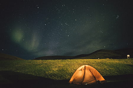 brown dome tent on green grass field during night time thumbnail