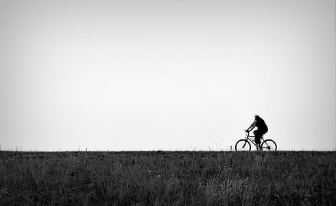 person riding on bicycle at road thumbnail