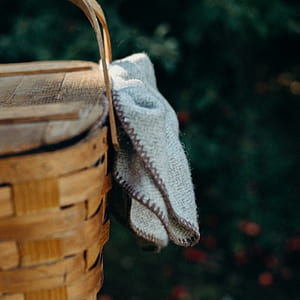 brown wicker basket and gray towel thumbnail
